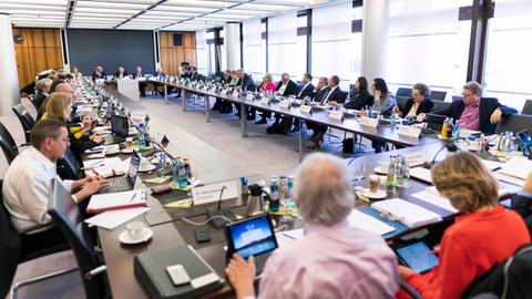 Mitglieder des Rundfunkrats sitzen in einem Konferenzraum um einen großen Konferenztisch herum